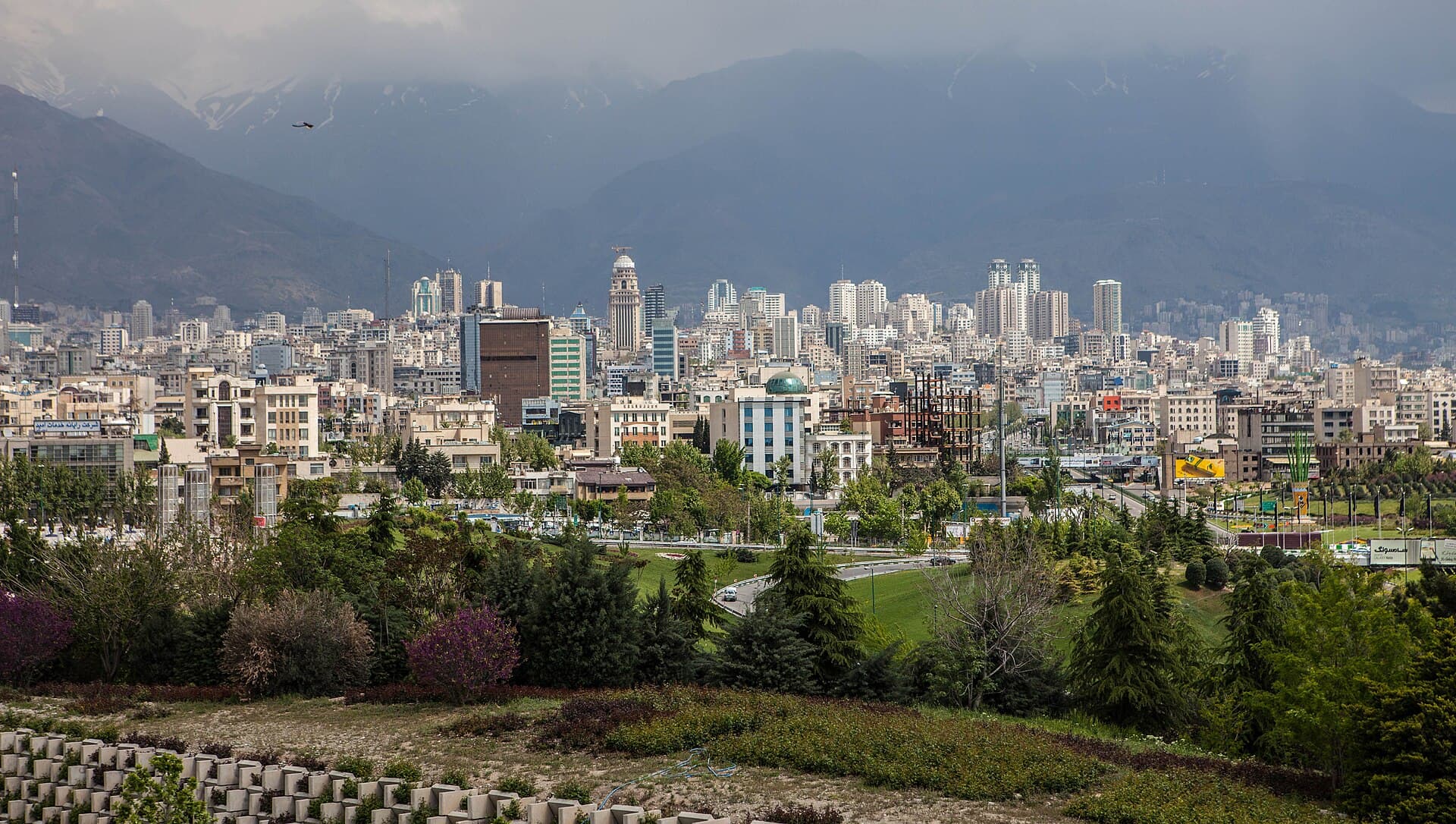 Panoramă a unui oraș iranian, cel mai probabil Teheran, cu munți în fundal. (Foto: ninara / CC BY 2.0, Wikimedia Commons)