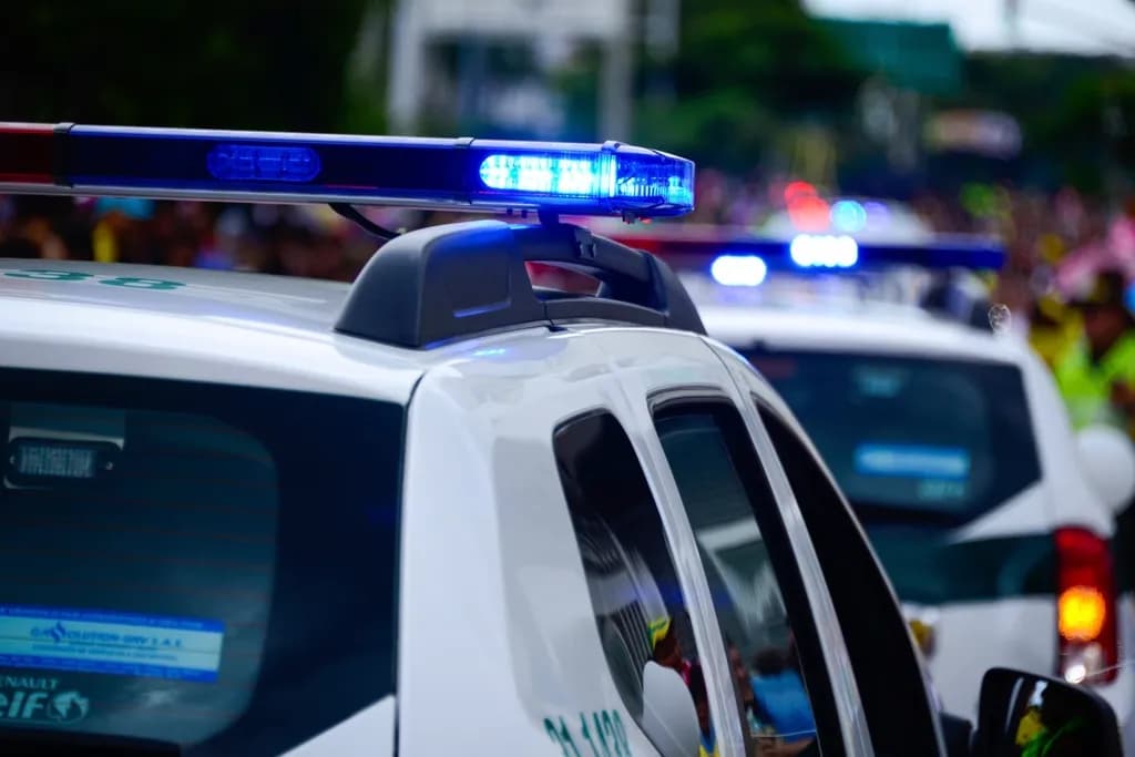 Mașini de poliție cu luminile albastre pornite, într-o zonă urbană. (Foto ilustrativă: necunoscut / CC0 1.0, Openverse)