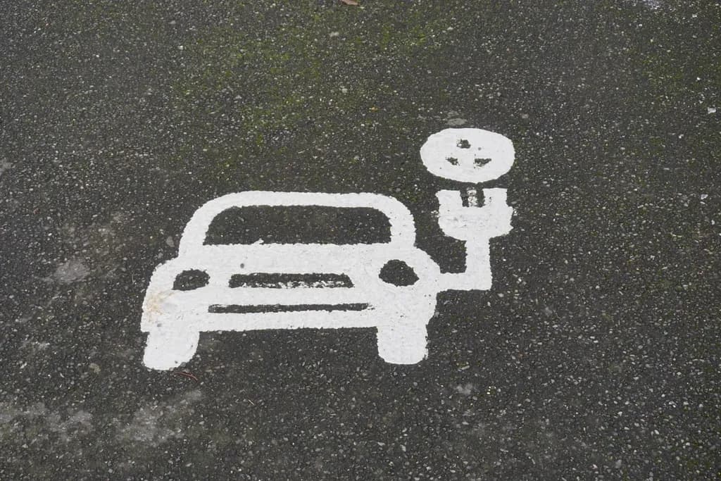 Marcaj rutier cu simbolul unei mașini electrice conectate la o stație de încărcare. (Foto ilustrativă: necunoscut / CC0 1.0, Openverse)