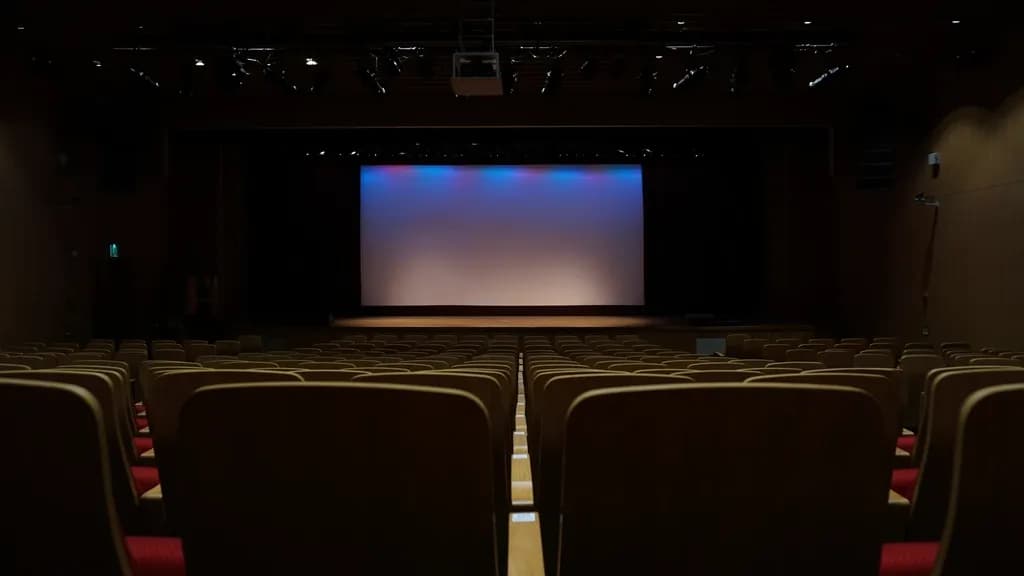 O sală de cinema goală, văzută dinspre public, cu ecranul și scena în fundal. (Foto ilustrativă: necunoscut / CC0 1.0, Openverse)