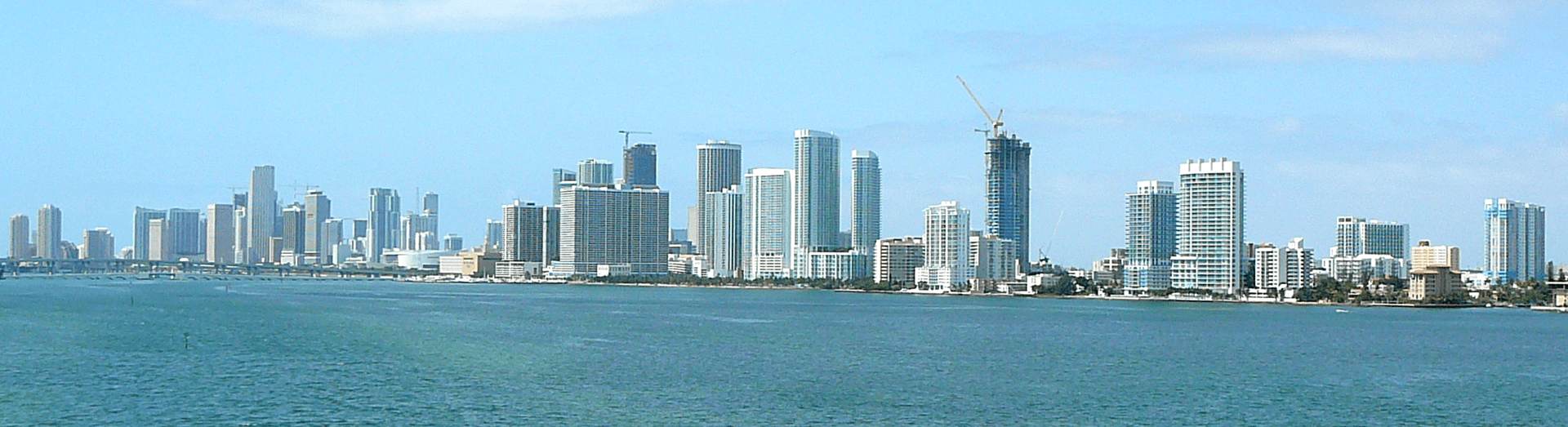 Panorama orașului Miami văzut de pe apă, cu clădiri înalte pe mal. (Foto: No machine-readable author provided. Averette assumed (based on copyright claims / CC BY 3.0, Wikimedia Commons)