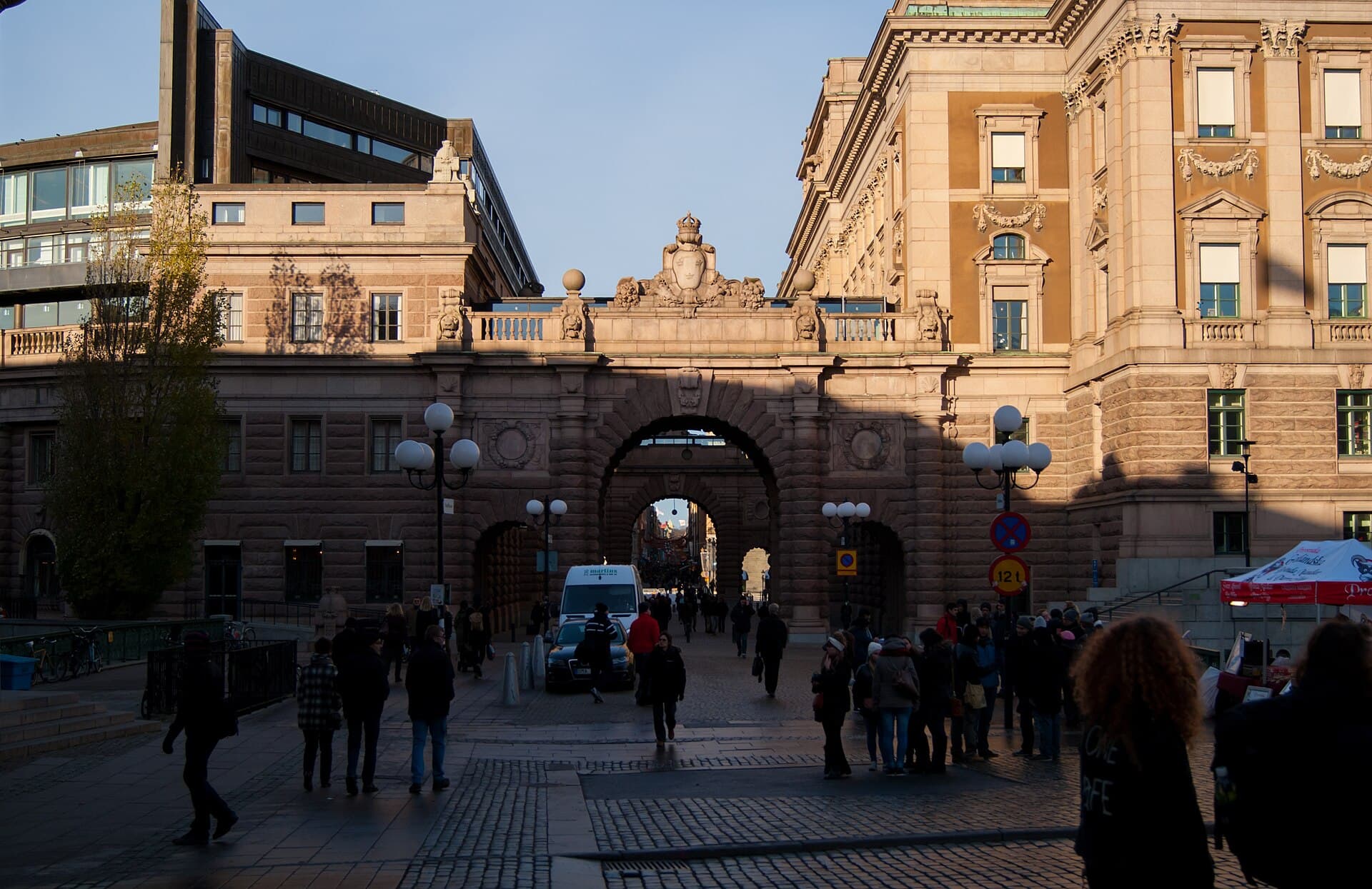 Clădire instituțională din Stockholm, aparent sediul Parlamentului Suediei (Riksdag), văzută din exterior, cu trecători în față. (Foto: Guillaume Speurt from Vilnius, Lithuania / CC BY-SA 2.0, Wikimedia Commons)