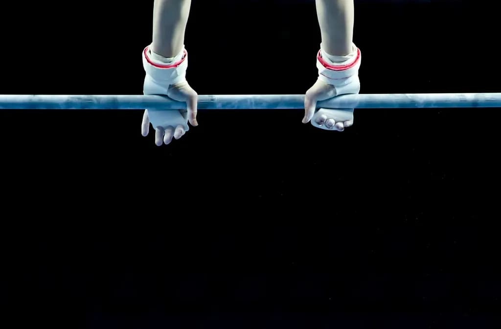 Mâinile unei gimnaste, cu bandaje, prinse de bara fixă. (Foto ilustrativă: necunoscut / CC0 1.0, Openverse)