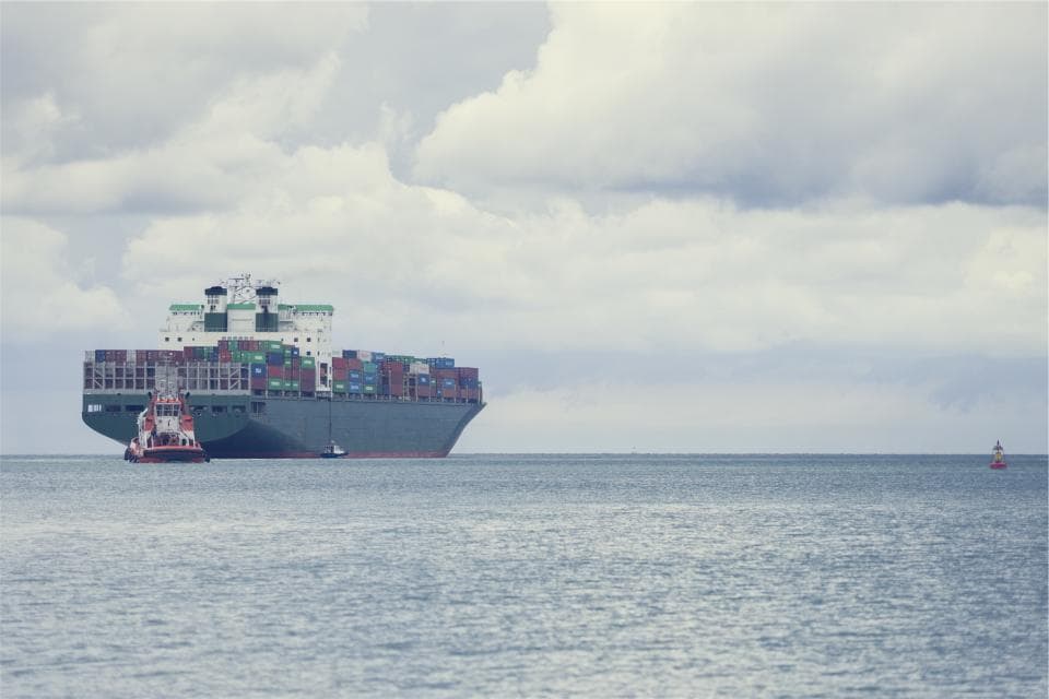 O navă mare de containere navigând pe mare, asistată de un remorcher. (Foto ilustrativă: Martin%20D%F6rsch / CC0 1.0, Openverse)