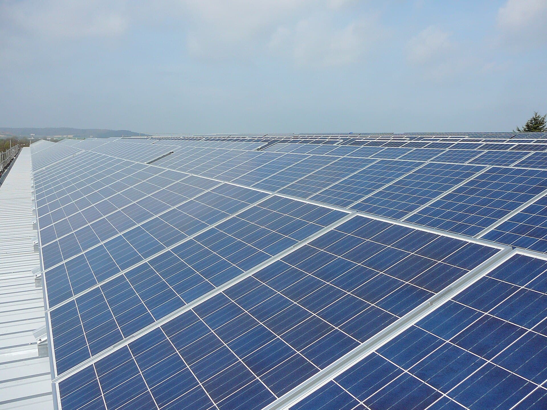 Un șir întins de panouri fotovoltaice montate pe acoperiș, sub un cer senin. (Foto de arhivă: ChristofferRiemer / CC BY 3.0, Wikimedia Commons)