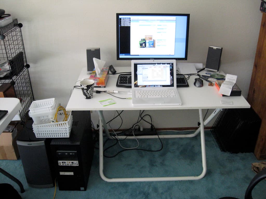 Un birou cu un computer și un laptop conectate, pe ale căror ecrane apar pagini web. (Foto de arhivă: houdini_cs / BY-SA 2.0, Openverse)