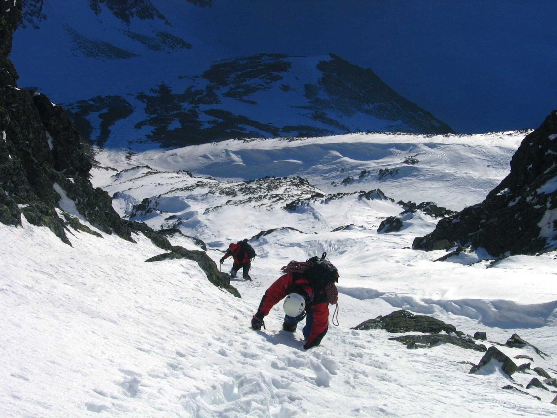 Doi alpiniști urcă pe un versant montan acoperit de zăpadă și gheață. (Foto de arhivă: Wikimol / CC BY-SA 3.0, Wikimedia Commons)