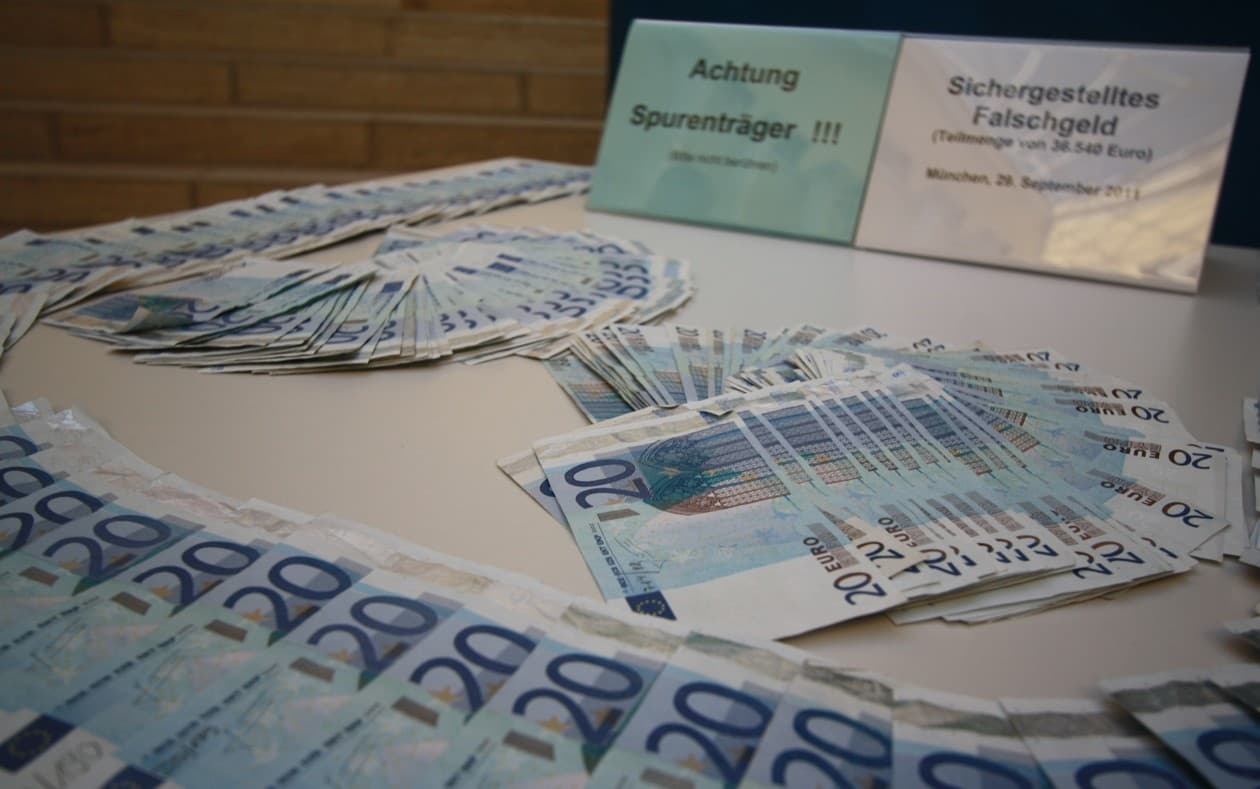 Bancnote euro de 20 și 50 de euro așezate pe o masă, alături de două plăcuțe cu text în limba germană. (Foto de arhivă: Michael Lucan / CC BY-SA 3.0 de, Wikimedia Commons)
