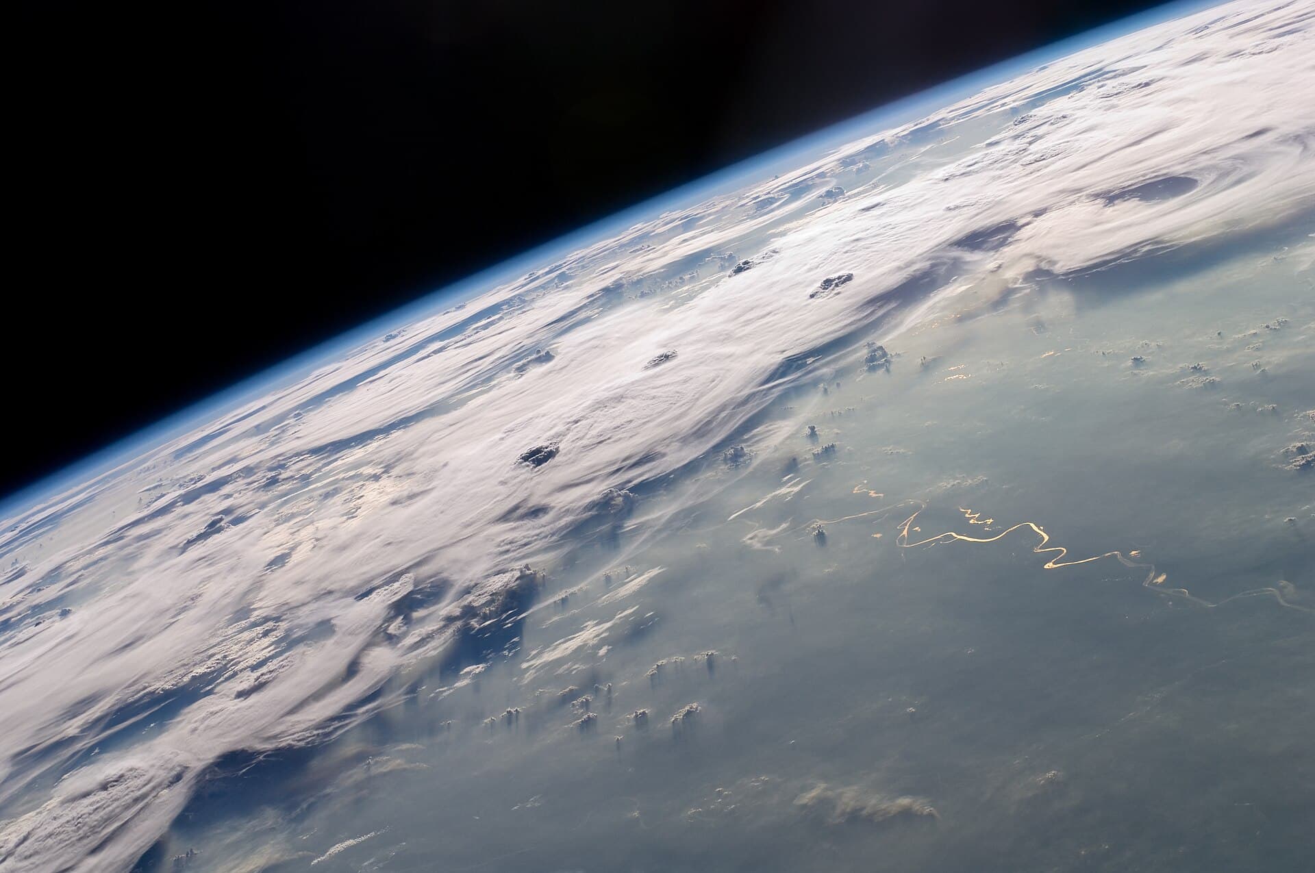 Imagine din satelit a Pământului, cu formațiuni noroase și suprafața terestră/vizibilă prin nori. (Foto de arhivă: NASA Expedition 20 crew / Public domain, Wikimedia Commons)