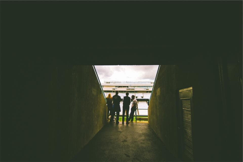 Un tunel de acces către un teren de fotbal, cu mai multe persoane văzute din spate. (Foto ilustrativă: Abigail Keenan / CC0 1.0, Openverse)