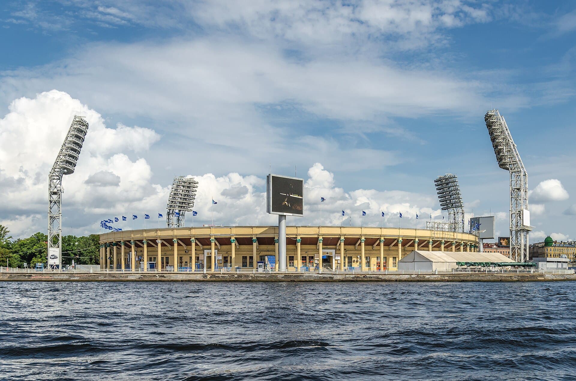 Un stadion de fotbal văzut de peste apă, cu tribunele și nocturna vizibile. (Foto de arhivă: Florstein ( Telegram: WikiPhoto.Space ) / CC BY-SA 4.0, Wikimedia Commons)