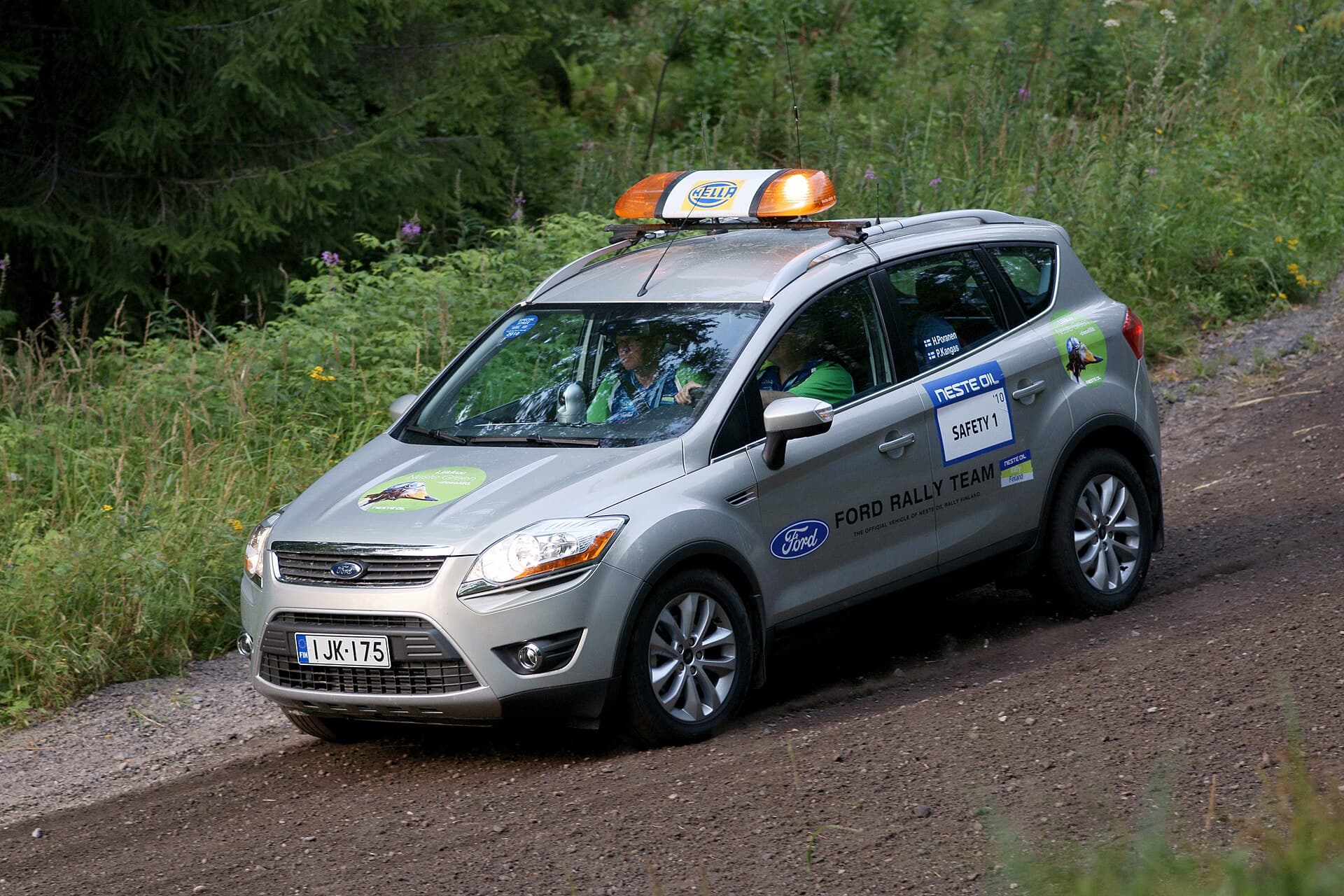 Un autoturism Ford al unei echipe de raliu, inscripționat „Ford Rally Team”, pe un drum forestier. (Foto de arhivă: kallerna / CC BY-SA 3.0, Wikimedia Commons)