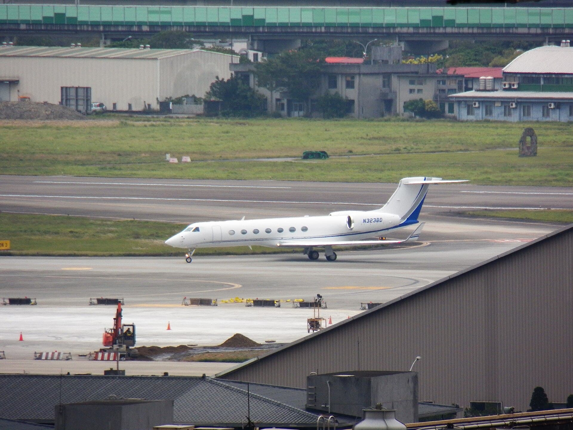 Un avion privat pe pista unui aeroport, în apropierea unor clădiri și hangare. (Foto de arhivă: 玄史生 / CC BY-SA 3.0, Wikimedia Commons)